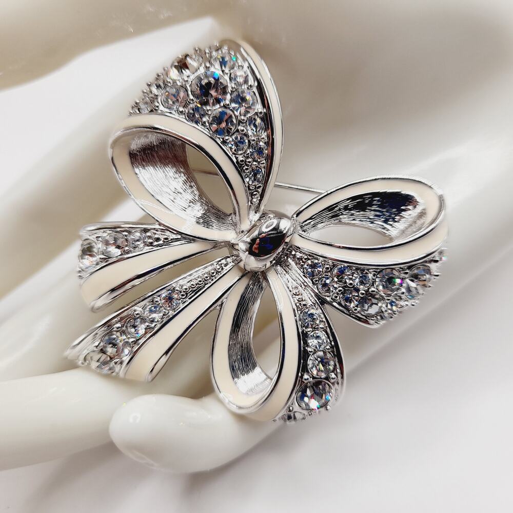 Vintage Nolan Miller Bow Brooch Rhodium Plated Clear Rhinestone White Enamel